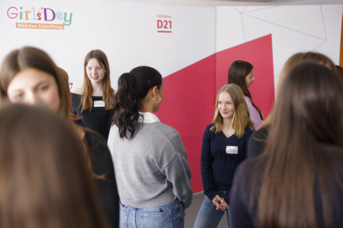 Verschiedene Schülerinnen stehen bei einer Kennenlernmethode im Pulk und lächeln